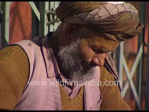Afghani women visit a cobbler in Kabul, Afganistan, to get their shoes fixed