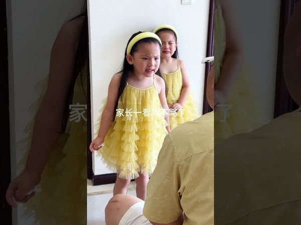 Watching her older sister being scolded  the younger sister holds back her tears and watches over h