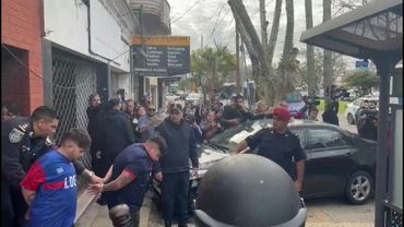 Football fans detained during violent clashes escorted out of a Buenos Aires police station | AFP