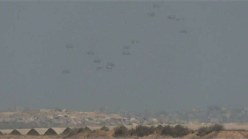 Parachutes fall from the sky during airdrop over northern Gaza | AFP