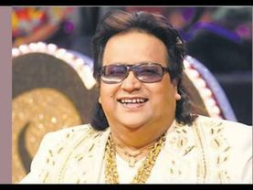 Bappi Lahiri in white kurta pajama with white boots and wearing a heavy gold chain at Shiksha event