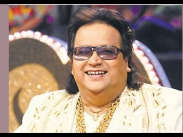 Bappi Lahiri in white kurta pajama with white boots and wearing a heavy gold chain at Shiksha event