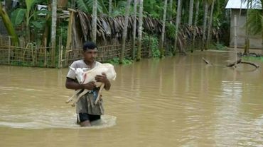 Locals wade through water after monsoon rains in northeast India leave dozens dead | AFP