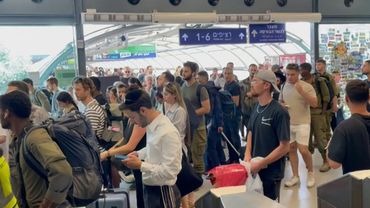People take shelter at Tel Aviv train station as air raid sirens sound | AFP