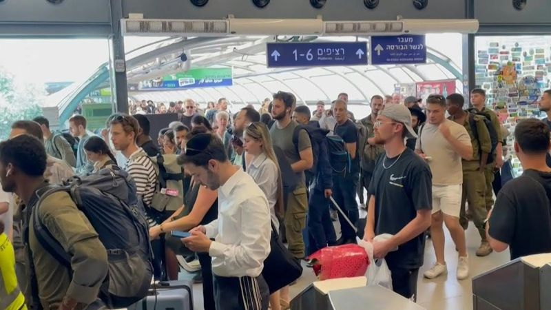 People take shelter at Tel Aviv train station as air raid sirens sound | AFP
