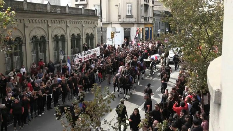 Supporters of Mujica stand outside building of political movement he founded | AFP
