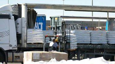 Workers unload humanitarian aid for Gaza at Kerem Shalom crossing | AFP