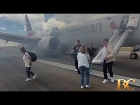 I passeggeri escono dall'aereo tramite lo scivolo di emergenza dopo il decollo interrotto