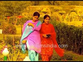 Kashmiri girls walk past fountains & autumn Chinar tree leaves at one of great gardens of Srinagar