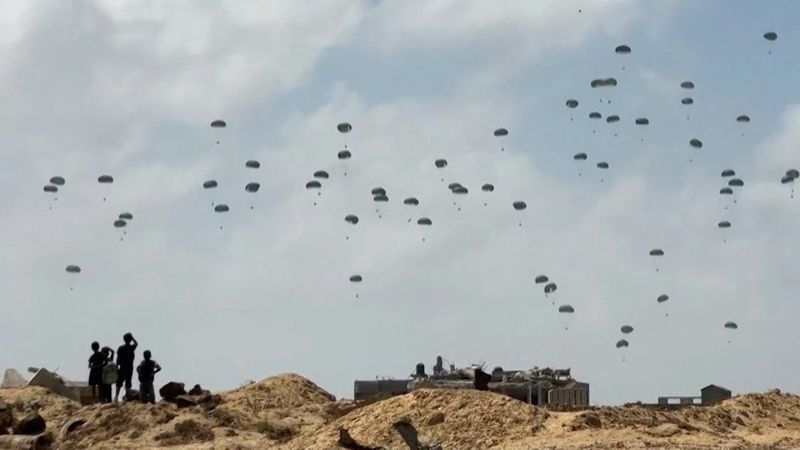 Parachutes fall during aid airdrop over the central Gaza Strip | AFP