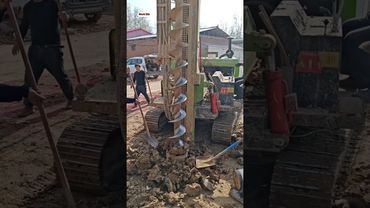 آلة حفارة صغيرة تحفر في الأرض لتثبيت الأعمدة