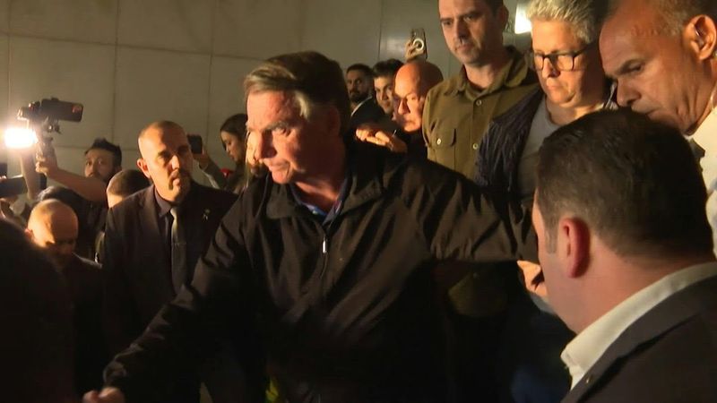 Brazil's ex-president Jair Bolsonaro flashes electronic ankle monitor to press | AFP