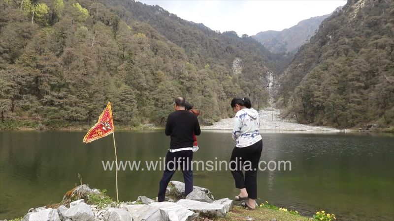 Summer rain at Dodital Lake beyond Uttarakashi, as a tourist family enjoys droplets of rain on lake