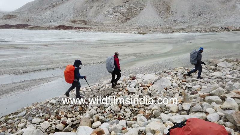 River crossing en route Kalindi Khal trek in Uttarakhand, in high altitude monsoon wet countryside