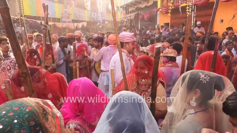 Women all prepared and excited to play Lathmar Holi at Barsana, with canes and sticks in hand!