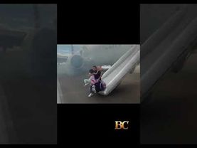 Passengers exit plane via emergency slide after aborted takeoff